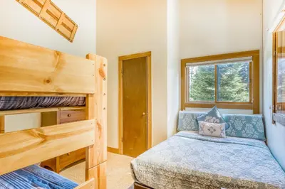 a bedroom with two bunk beds and a window at Cheery Gold Bend Family Condo in Truckee