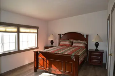 a bedroom with a bed with two lamps and two windows at In The Oaks in Three Rivers