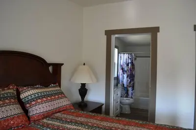 a bedroom with a bed and a bathroom with a shower at In The Oaks in Three Rivers