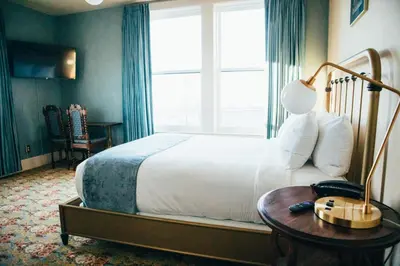 a bedroom with a bed and a table and a window at Belvada Hotel in Tonopah