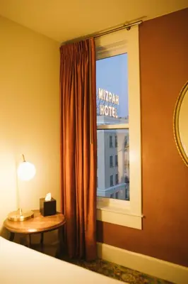 a bedroom with a window with a hotel sign on it at Belvada Hotel in Tonopah