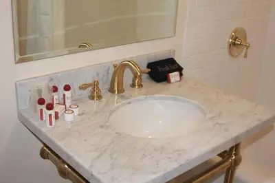a bathroom counter with a sink with cosmetics on it at Belvada Hotel in Tonopah