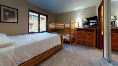 a bedroom with a bed and a desk with a television at Helios North #6 condo in Mammoth Lakes