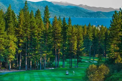 a golf course with trees and a view of a lake at Incline Oasis in Incline Village
