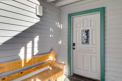 a white door with a bench in front of a house at Snowcreek Resort Condo with Deck at Mammoth Mountain in Mammoth Lakes