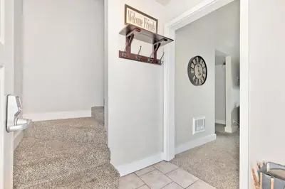 a hallway with stairs and a clock on the wall at La Vista Blanc 78 in Mammoth Lakes