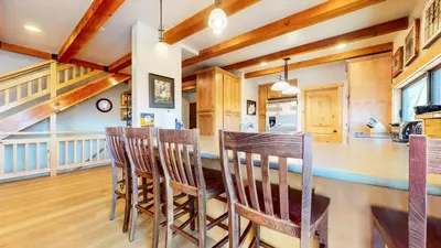 a kitchen with wooden ceilings and a bar with chairs at Val DIsere #10 condo in Mammoth Lakes
