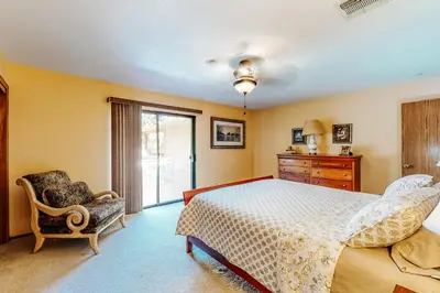 a bedroom with a bed and a chair and a window at Summer Creek in Groveland