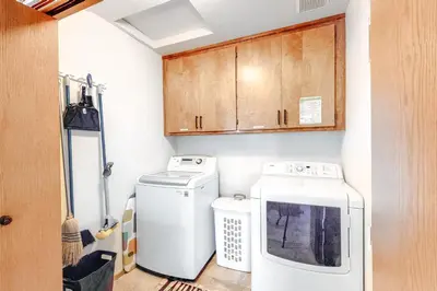 a laundry room with a washer and dryer and cabinets at Summer Creek in Groveland