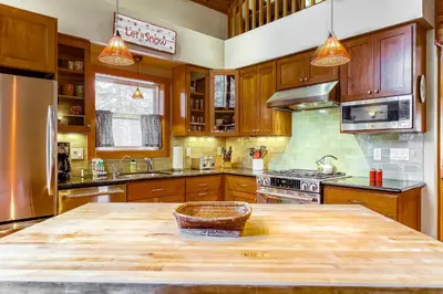 a kitchen with wooden cabinets and a wooden table at Sugar House in Soda Springs