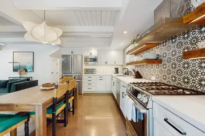 a kitchen with white cabinets and a wooden table at Bearing Drive Escape in Tahoe City