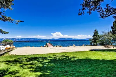 a beach with a bench and the water at Bearing Drive Escape in Tahoe City