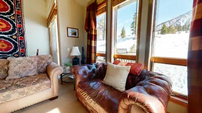 a living room with a leather couch and a window at Snowcreek V #774 condo in Mammoth Lakes