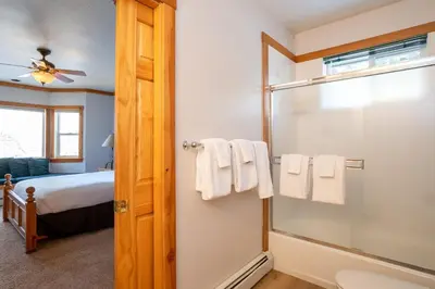 a bathroom with a glass shower and a bed at Skidder Trail Family Lodge home in Truckee