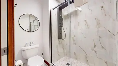 a bathroom with a shower with a toilet and a mirror at Eagle Run #103 condo in Mammoth Lakes