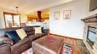 a living room with a brown couch and a fireplace at Eagle Run #103 condo in Mammoth Lakes