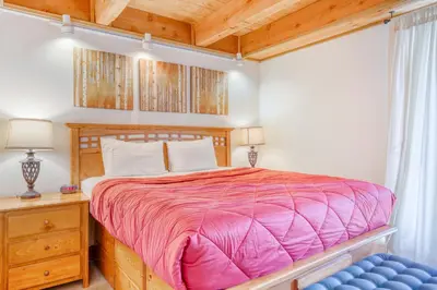 a bedroom with a wooden bed and a blue chair at Northstar Perch in Truckee