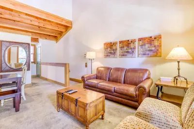 a living room with a leather couch and a table at Northstar Perch in Truckee