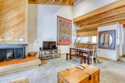 a living room with a table and a fireplace at Northstar Perch in Truckee