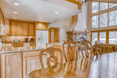 a kitchen with wooden cabinets and a table with chairs at Four Seasons Lakeside in Soda Springs