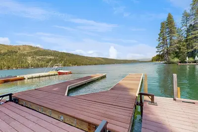 a dock on a lake with a boat in the water at Beaver Cove Lodge in Truckee
