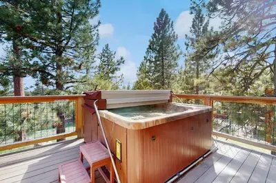 a wooden deck with a hot tub and a chair at Fabian Holidays in Tahoe City