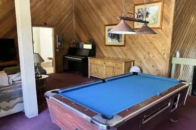 a room with a pool table and a piano at Crestview 36 in Mammoth Lakes