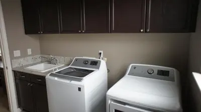 a small kitchen with a washer and a sink at Modern Luxury Living, relax and enjoy your stay! in Rancho Cordova
