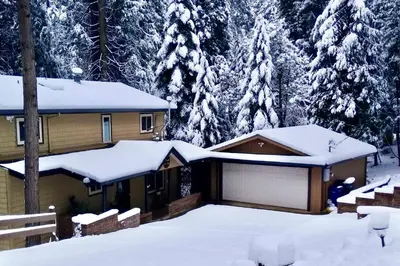 a house covered in snow with trees in the background at Near Hiking Trails Cabin with Deck in Pioneer! in Pioneer