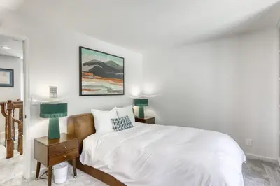a white bedroom with a bed and two lamps at Captains Quarters Retreat in Zephyr Cove