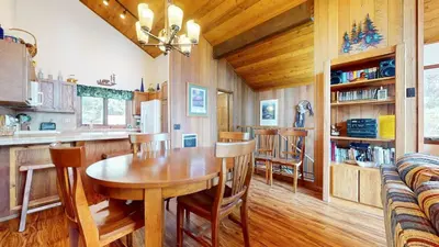 a kitchen and dining room with a wooden table and chairs at Meadow Ridge #28 condo in Mammoth Lakes