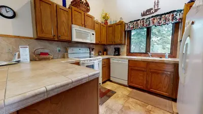 a kitchen with wooden cabinets and a white refrigerator at Meadow Ridge #28 condo in Mammoth Lakes