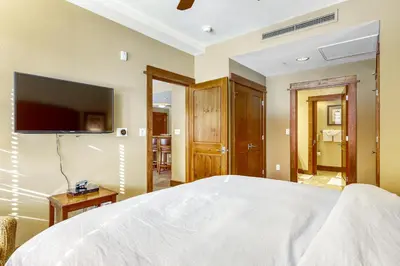 a bedroom with a white bed and a television at Northstar Village #410 in Kingswood Estates