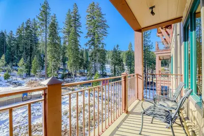 a balcony with a chair and a view of the woods at Northstar Village #410 in Kingswood Estates