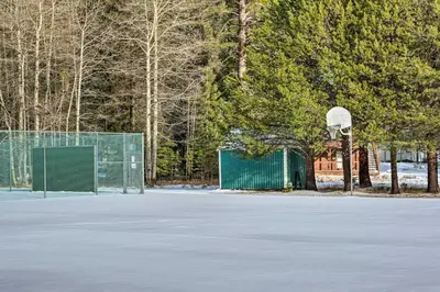 an empty tennis court with a basketball hoop at Pinecrest Retreat with Fireplace! in Pinecrest
