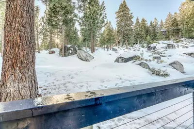 a wooden deck in the snow next to a tree at Heavenly Hideaway in Stateline