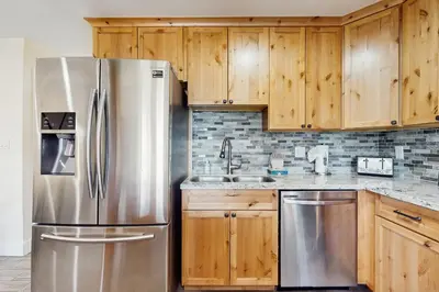 a kitchen with a stainless steel refrigerator and wooden cabinets at Heavenly Hideaway in Stateline