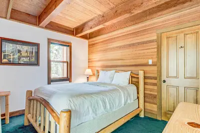 a bedroom with a bed and a wooden wall at Snowdream in Ponderosa Fairway Estates