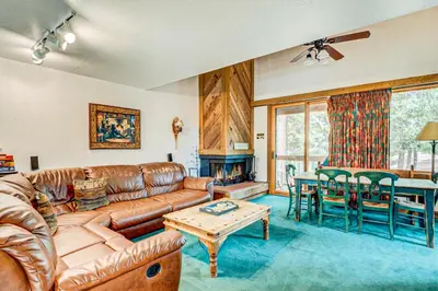 a living room with a leather couch and a table at Snowdream in Ponderosa Fairway Estates