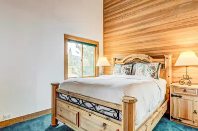 a bedroom with a bed and a wooden wall at Snowdream in Ponderosa Fairway Estates