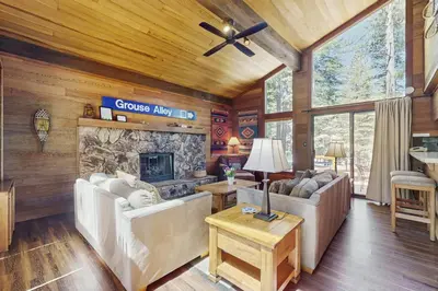 a living room with couches and a stone fireplace at Indian Hill Hush in Truckee