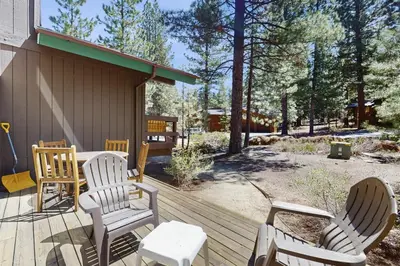 a wooden deck with chairs and a table and a building at Indian Hill Hush in Truckee