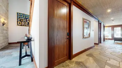 a hallway with a wooden door and a table at Obsidian #7 home in Mammoth Lakes