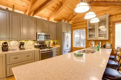 a large kitchen with a large island in a log cabin at 1 Mi to Heavenly Resort Cozy Home with Deck! in Stateline
