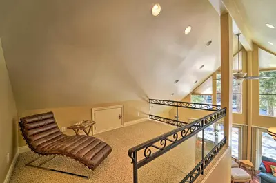 a living room with a chair and a staircase at 4 Mi to Dtwn Truckee Tahoe Donner Home with Hot Tub in Truckee