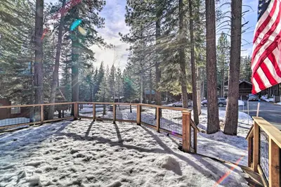 a deck covered in snow with an american flag at 4 Mi to Dtwn Truckee Tahoe Donner Home with Hot Tub in Truckee