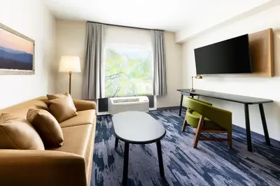 a hotel room with a couch and a desk at Fairfield Inn & Suites by Marriott Oakhurst Yosemite in Oakhurst