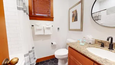 a bathroom with a toilet and a sink and a mirror at Timbers #6 townhouse in Mammoth Lakes