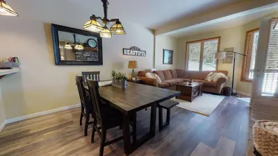 a dining room and living room with a table and chairs at Mammoth Green #102 condo in Mammoth Lakes