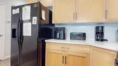 a kitchen with a black refrigerator and wooden cabinets at Mammoth Green #102 condo in Mammoth Lakes